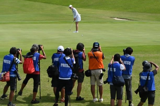 Media photographers are seen as Kana Mikashima of Japan attempts a putt on the 17th green during the final round of Yonex Ladies at Yonex Country...