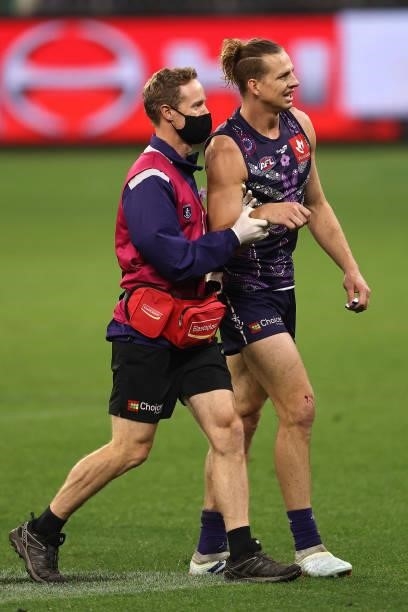 Nat Fyfe of the Dockers is assisted from the field by the club doctor with a shoulder injury during the round 12 AFL match between the Fremantle...