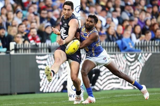 Jacob Weitering of the Blues kicks as he is tackled by Liam Ryan of the Eagles during the round 12 AFL match between the Carlton Blues and the West...