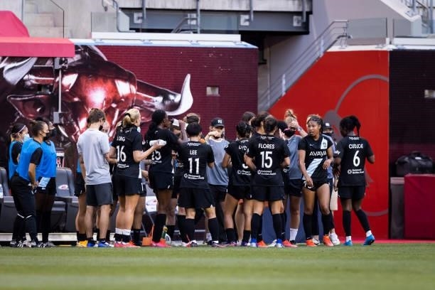 Members of the NJ/NY Gotham FC team huddle during a mandatory water break during the first half of the match against OL Reign at Red Bull Arena on...