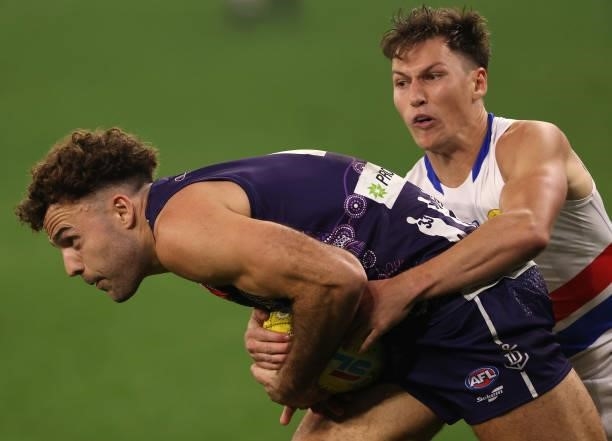 Griffin Logue of the Dockers gets tackled by Anthony Scott of the Bulldogs during the round 12 AFL match between the Fremantle Dockers and the...