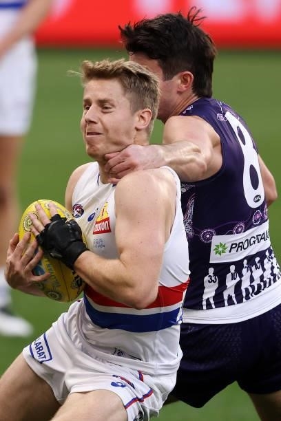 Lachie Hunter of the Bulldogs gets tackled high by Andrew Brayshaw of the Dockers during the round 12 AFL match between the Fremantle Dockers and the...