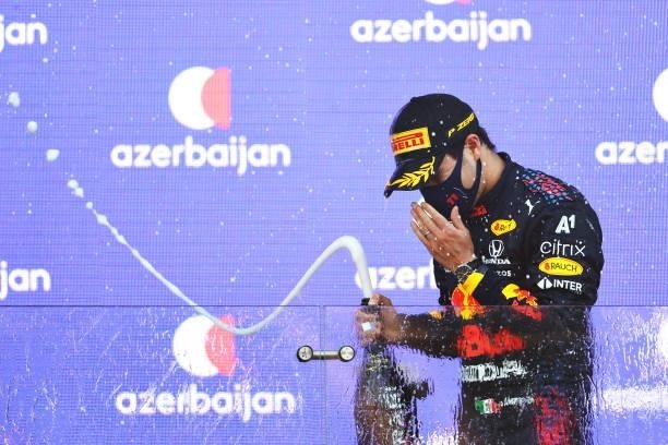 Race winner Sergio Perez of Mexico and Red Bull Racing celebrates with sparkling wine on the podium during the F1 Grand Prix of Azerbaijan at Baku...