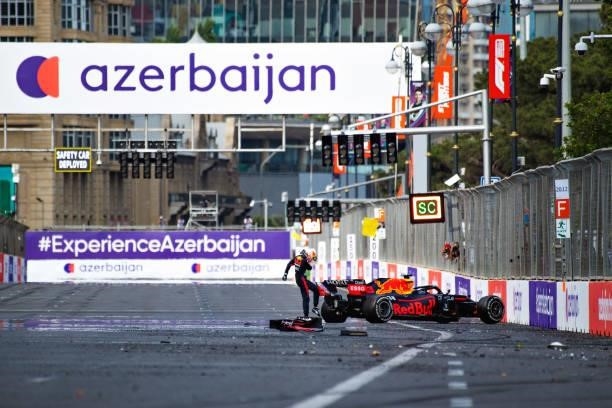 Max Verstappen of Netherlands and Red Bull Racing kicks his tyre as he reacts after crashing during the F1 Grand Prix of Azerbaijan at Baku City...