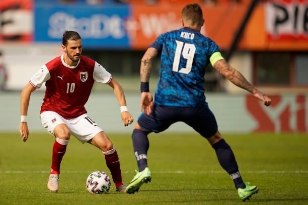 Florian Grillitsch of Austria runs with the ball whilst under pressure from Juraj Kucka of Slovakia during the international friendly match between...