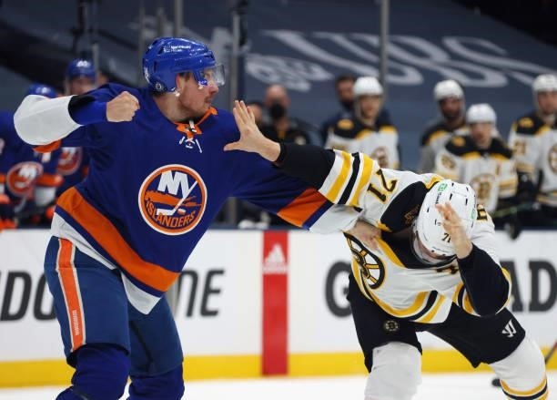 Taylor Hall of the Boston Bruins and Scott Mayfield of the New York Islanders fight during the first period in Game Four of the Second Round of the...