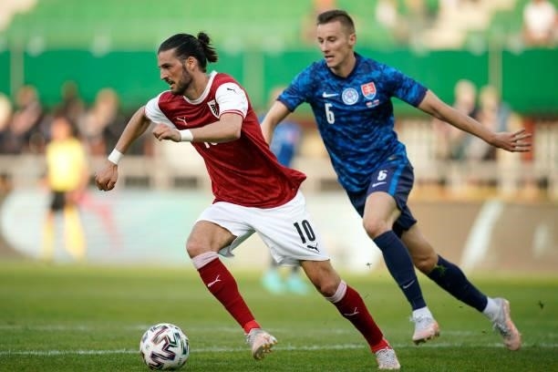 Florian Grillitsch of Austria runs with the ball whilst under pressure from Jan Gregus of Slovakia during the international friendly match between...