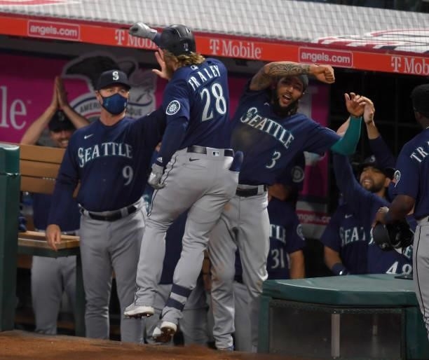 Jake Fraley is congratulated by Scott Servais, manager, and J.P. Crawford of the Seattle Mariners after hitting a grand slam home run in the fourth...