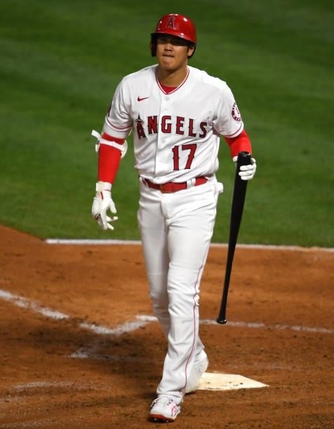 Shohei Ohtani of the Los Angeles Angels walks back to the dugout after striking out in the game against the Seattle Mariners at Angel Stadium of...