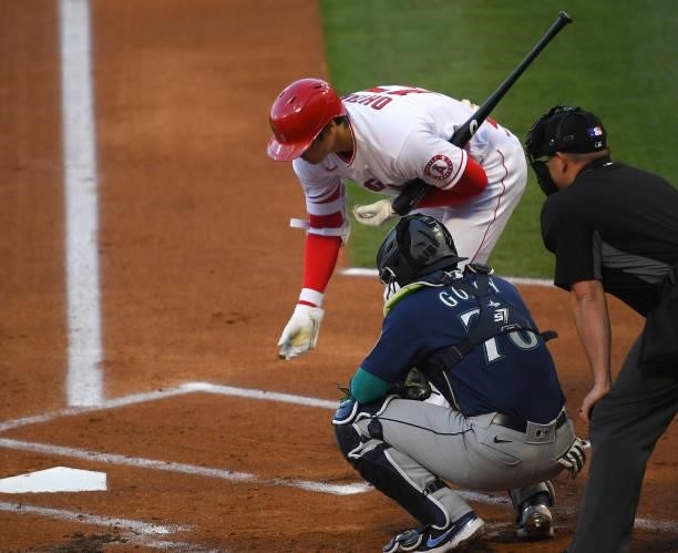 Shohei Ohtani of the Los Angeles Angels clears a rock from the ground before stepping in to hit a solo home in the first inning of the game off Yusei...