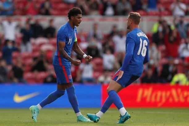Marcus Rashford of England celebrates with team mate Jordan Henderson after scoring their side's first goal from the penalty spot during the...