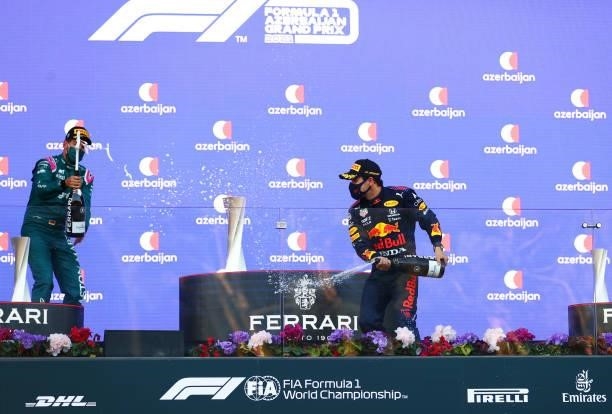 Race winner Sergio Perez of Mexico and Red Bull Racing, second placed Sebastian Vettel of Germany and Aston Martin F1 Team and third placed Pierre...