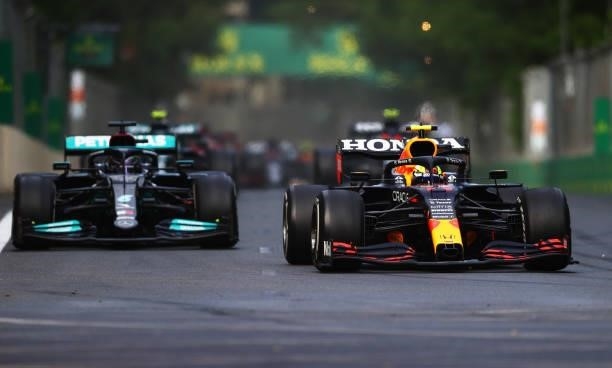 Sergio Perez of Mexico driving the Red Bull Racing RB16B Honda leads Lewis Hamilton of Great Britain driving the Mercedes AMG Petronas F1 Team...