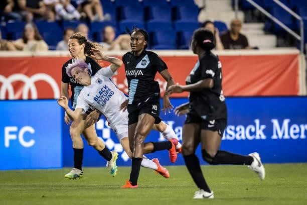 Megan Rapinoe of OL Reign is taken down by Mandy Freeman of NJ/NY Gotham FC and two other defenders during the second half of the match against NJ/NY...