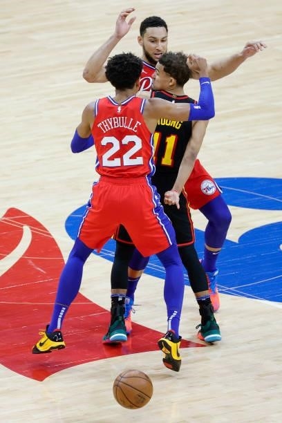 Trae Young of the Atlanta Hawks passes between Ben Simmons and Matisse Thybulle of the Philadelphia 76ers during the fourth quarter during Game One...