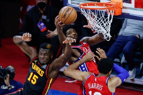 Clint Capela of the Atlanta Hawks tangles with Joel Embiid of the Philadelphia 76ers during the fourth quarter during Game One of the Eastern...
