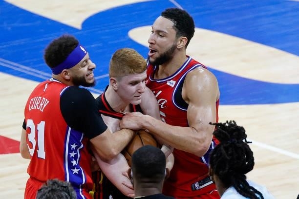 Seth Curry and Ben Simmons of the Philadelphia 76ers guard Kevin Huerter of the Atlanta Hawks during the fourth quarter during Game One of the...