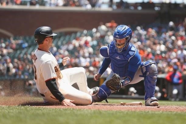 Catcher P.J. Higgins of the Chicago Cubs tags out Buster Posey of the San Francisco Giants at home plate in the bottom of the second inning at Oracle...