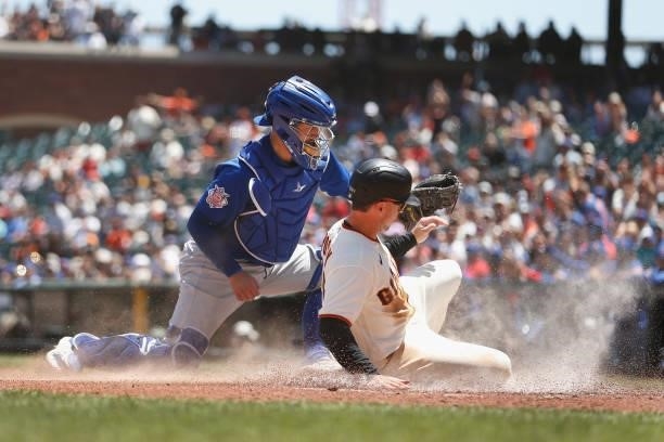 Catcher P.J. Higgins of the Chicago Cubs tags out Buster Posey of the San Francisco Giants at home plate in the bottom of the second inning at Oracle...