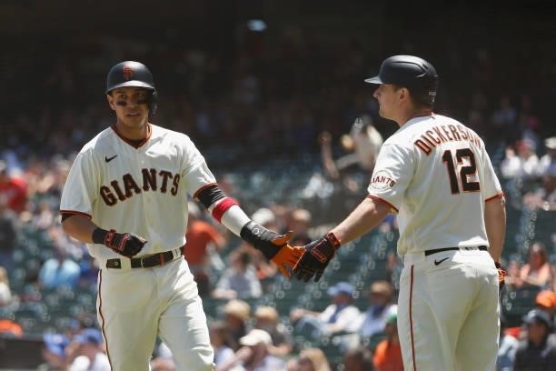 Mauricio Dubon of the San Francisco Giants celebrates with Alex Dickerson after scoring on a double by Buster Posey in the bottom of the second...