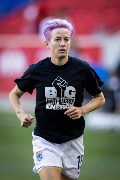 Megan Rapinoe of OL Reign wears a tee shirt that says Big Anti-Racist Energy with a Black Power Fist on it as she warms up before the match against...