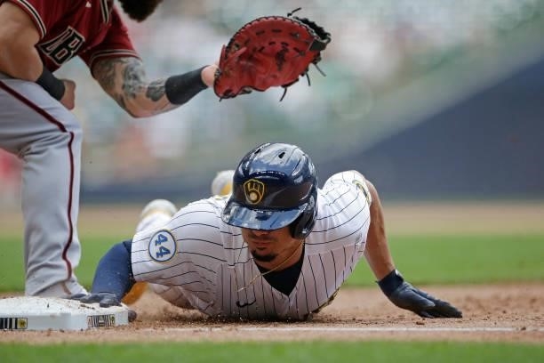 Willy Adames of the Milwaukee Brewers dives back to first base in the seventh inning against the Arizona Diamondbacks at American Family Field on...