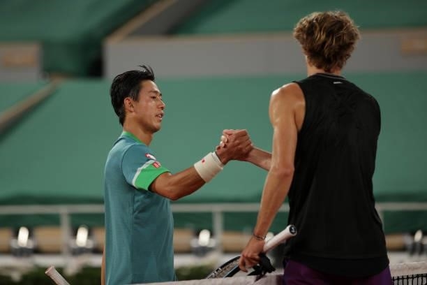 Alexander Zverev of Germany shakes hands with Kei Nishikori of Japan after winning his Men's Singles fourth round match on day eight of the 2021...