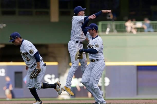 Willy Adames, Luis Urias and Daniel Robertson of the Milwaukee Brewers celebrate a win against the Arizona Diamondbacks at American Family Field on...