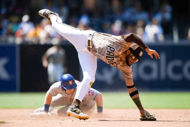 Billy McKinney of the New York Mets steals second base as Fernando Tatis Jr. #23 of the San Diego Padres leaps over fielding the throw in the sixth...