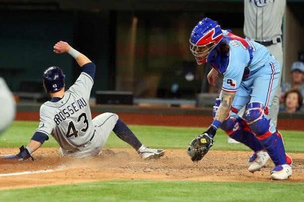 Mike Brosseau of the Tampa Bay Rays scores as Jonah Heim of the Texas Rangers gets the ball late in the eighth inning at Globe Life Field on June 06,...