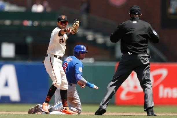 Mauricio Dubon of the San Francisco Giants looks to the umpire as Ian Happ of the Chicago Cubs slides in safely to second base in the top of the...