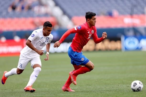 Alonso Martinez of Costra Rica advances the ball against Edwin Rodriguez of Honduras in the first half during the third place match of the Finals of...