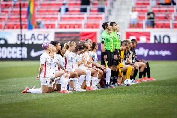 The starting lineup of OL Reign and NJ/NY Gotham FC kneel for the national anthem before the match at Red Bull Arena on June 5, 2021 in Harrison, New...