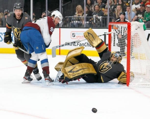 Andre Burakovsky of the Colorado Avalanche crashes upends Marc-Andre Fleury of the Vegas Golden Knights after Fleury blocked his shot as Brayden...