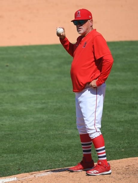 Manager Joe Maddon of the Los Angeles Angels holds the ball as he waits on the mound during a pitching change in the game against the Seattle...