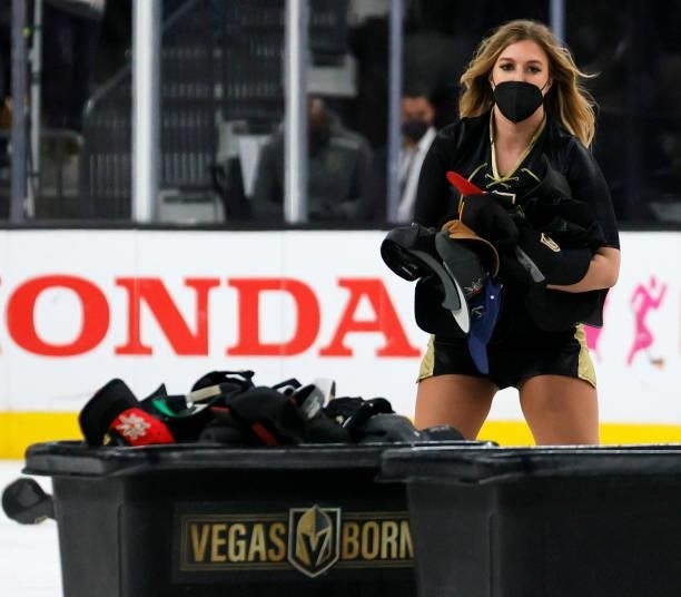 Member of the Knights Guard collects hats thrown on the ice after Jonathan Marchessault of the Vegas Golden Knights scored his third goal of the game...