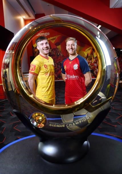 Ryan Strain and Stefan Mauk of Adelaide United look through the clubs 2016 A -League Champions Trophy during the 2021 A-League Finals Launch at...