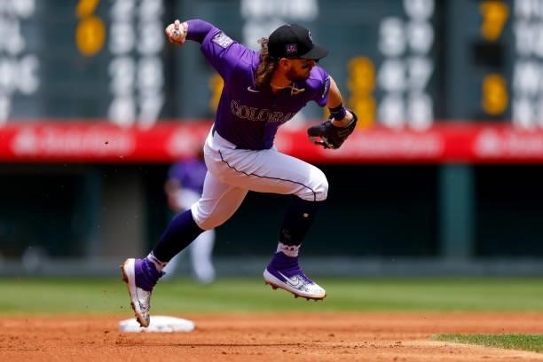 Shortstop Brendan Rodgers of the Colorado Rockies fields a ground ball barehanded before making a throw to first base for an out during the second...
