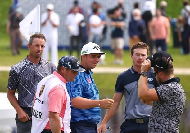Marcus Armitage of England is congratulated by his playing partners on the 18th green following his round during Day Three of The Porsche European...