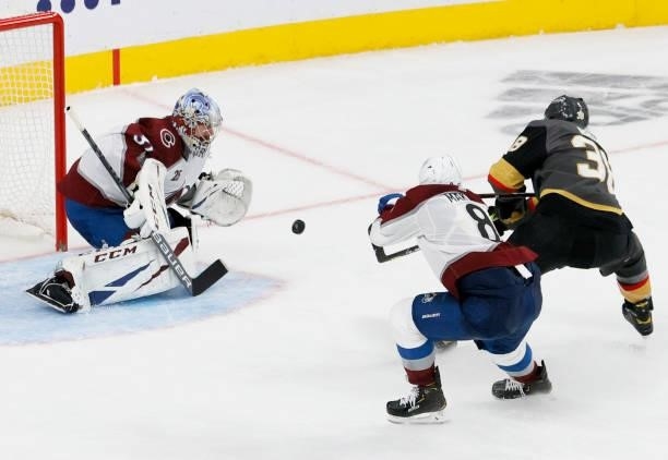 Patrick Brown of the Vegas Golden Knights shoots against Philipp Grubauer of the Colorado Avalanche for a goal as Cale Makar of the Avalanche defends...