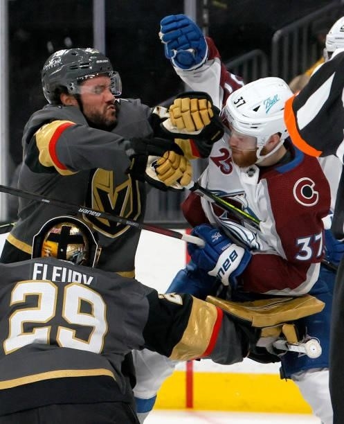 Alec Martinez of the Vegas Golden Knights and J.T. Compher of the Colorado Avalanche scuffle above Marc-Andre Fleury of the Golden Knights after he...