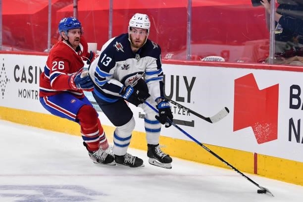 Pierre-Luc Dubois of the Winnipeg Jets skates the puck against Jeff Petry of the Montreal Canadiens during the first period in Game Three of the...