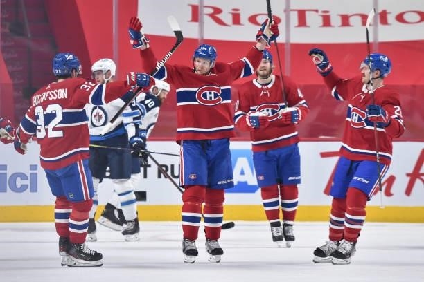 Corey Perry of the Montreal Canadiens raises his arms as his teammates join him to celebrate his goal against the Winnipeg Jets during the first...