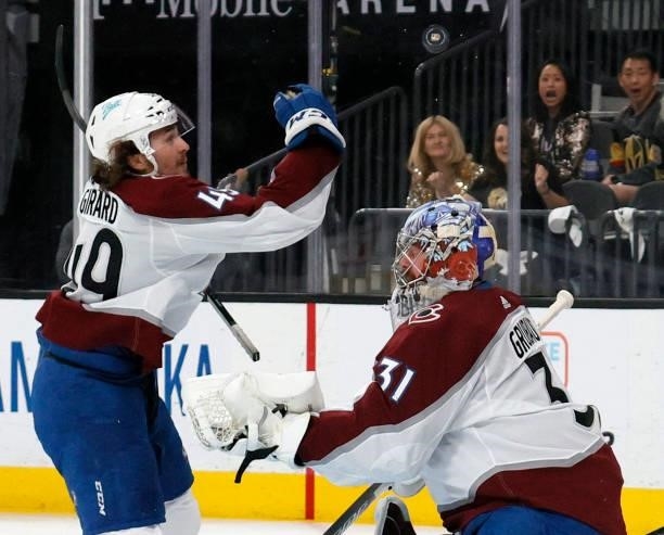 Samuel Girard of the Colorado Avalanche bats the puck away with his hand after Philipp Grubauer of the Avalanche blocked a shot by William Karlsson...
