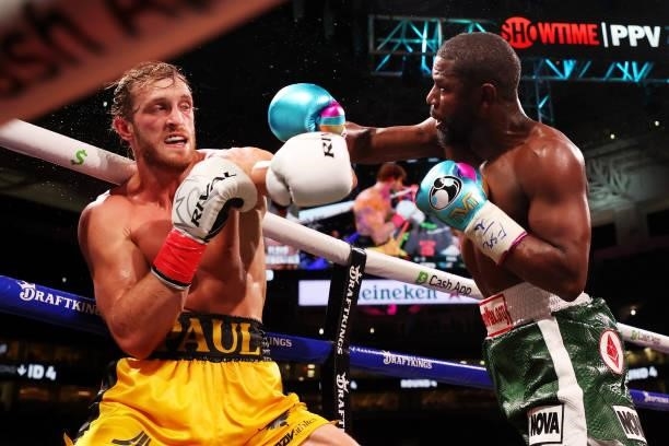 Floyd Mayweather exchanges blows with Logan Paul during their contracted exhibition boxing match at Hard Rock Stadium on June 06, 2021 in Miami...