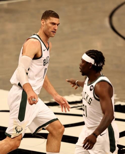 Brook Lopez of the Milwaukee Bucks celebrates his three point shot with teammate Jrue Holiday in the first half against the Brooklyn Nets during game...
