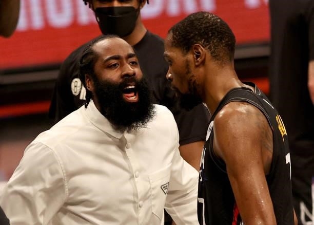 James Harden of the Brooklyn Nets congratulates teammate Kevin Durant after the third quarter against the Milwaukee Bucks during game two of the...