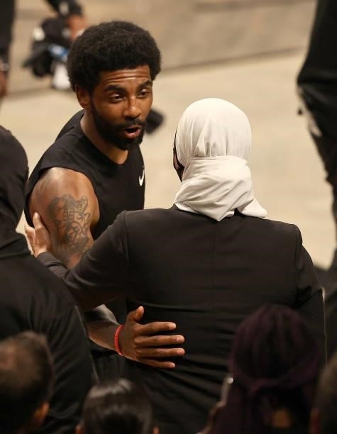 Kyrie Irving of the Brooklyn Nets talks to Manhattan district attorney candidate Tahanie Aboushi after game two of the Eastern Conference second...