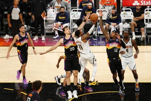 Monte Morris of the Denver Nuggets puts up a shot over Devin Booker and Torrey Craig of the Phoenix Suns during the first half in Game One of the...