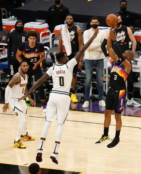 Chris Paul of the Phoenix Suns attempts a shot over JaMychal Green of the Denver Nuggets during the first half in Game One of the Western Conference...